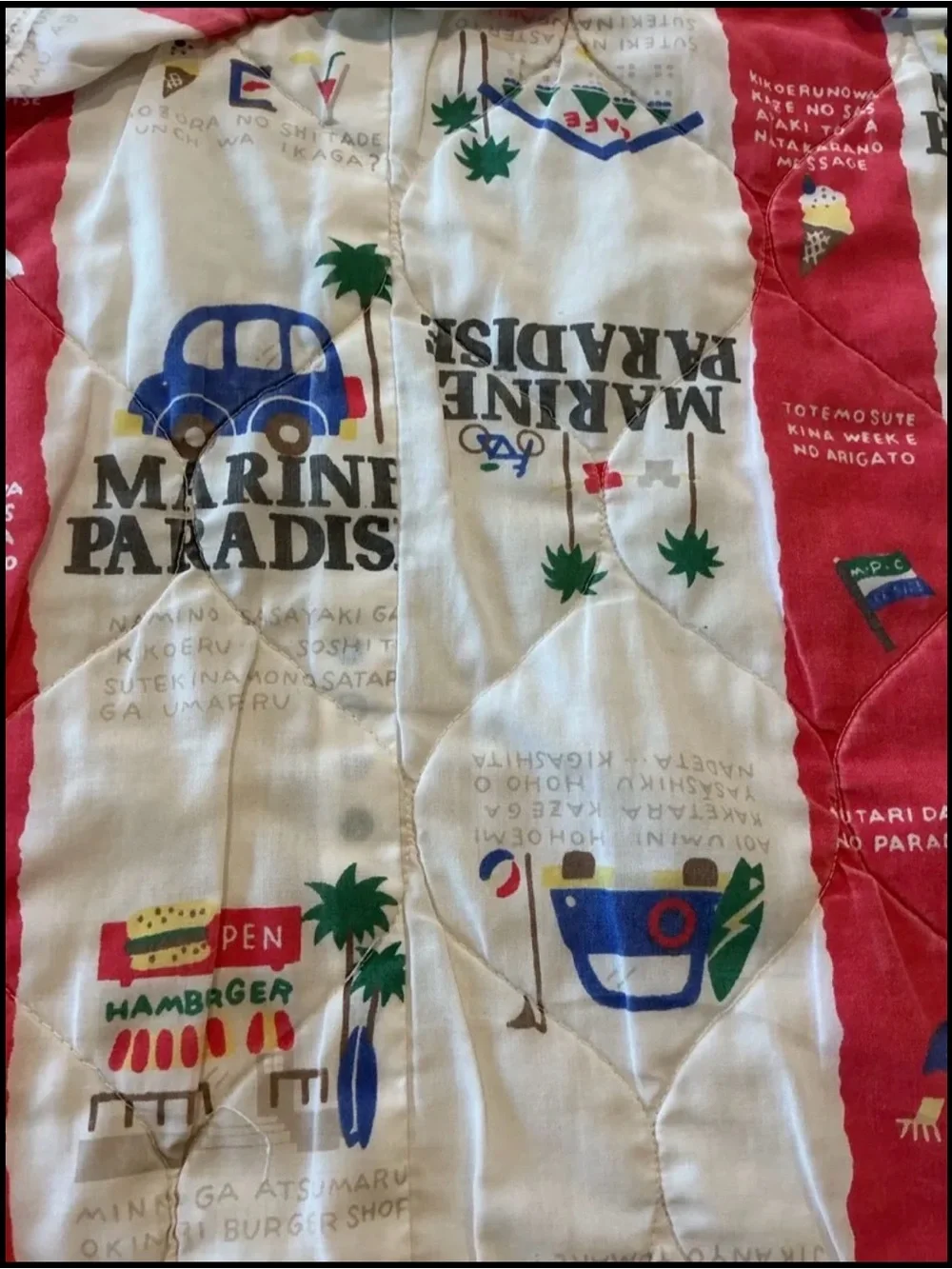 Vintage Marine Paradise quilted blanket featuring a colorful red and cream novel